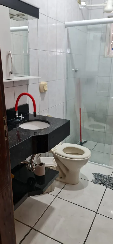 Banheiro com bancada, vaso sanitário e box de vidro