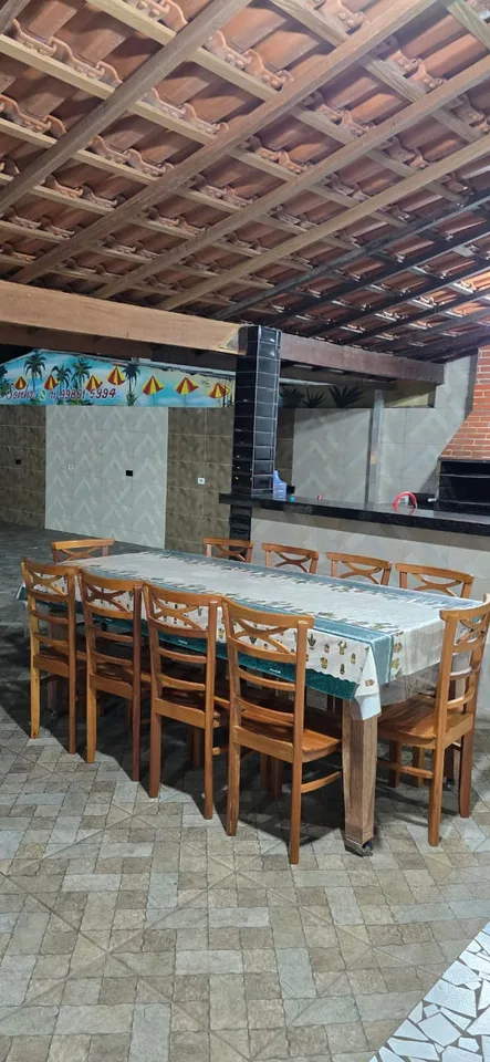 Mesa de madeira na área coberta da churrasqueira